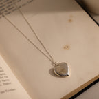 Flatlay of our our Fingerprint Heart Locket Necklace in Silver
