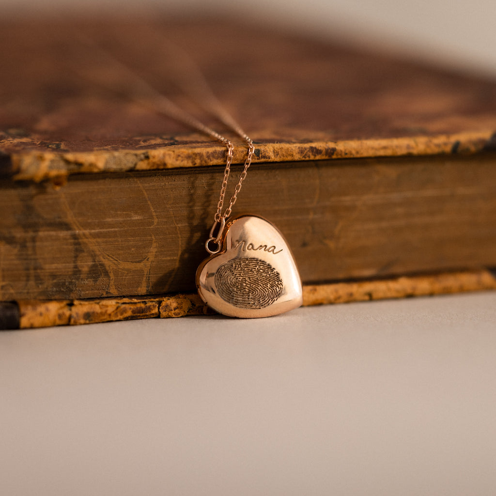 Close up flatlay of our Fingerprint Heart Locket Necklace in Rose Gold