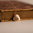 Close up flatlay of our Fingerprint Heart Locket Necklace in Rose Gold