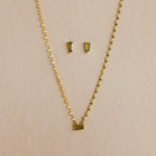Tapered Baguette Birthstone Studs and a gold chain necklace with a rectangular pendant are displayed together against a neutral background.