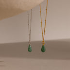 Two satellite chain necklaces in gold and silver, each featuring a single green jade teardrop gemstone pendant.