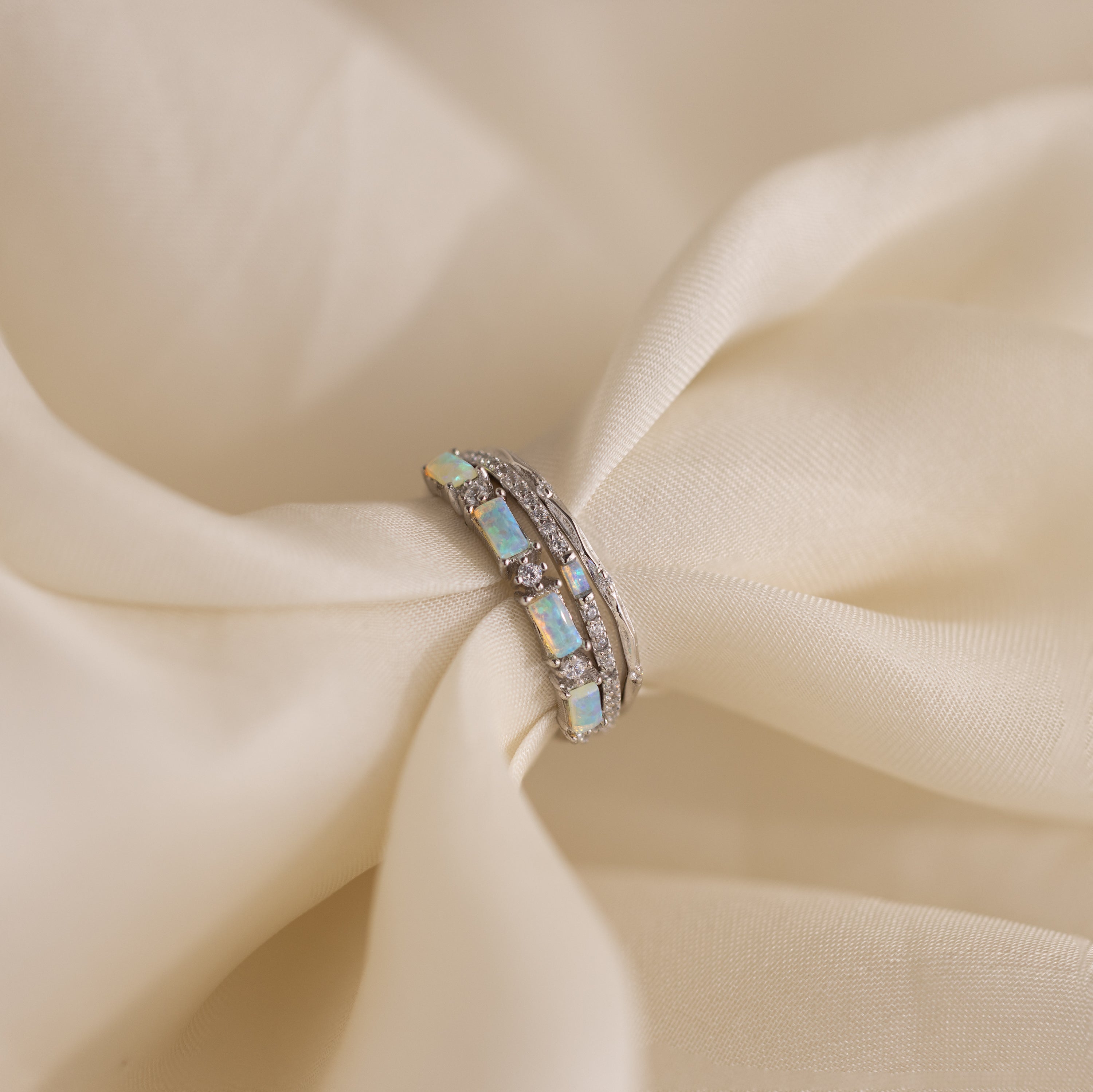 Pave Opal Ring Set in Sterling Silver with diamond accents and a timeless design, displayed on soft, cream-colored fabric.