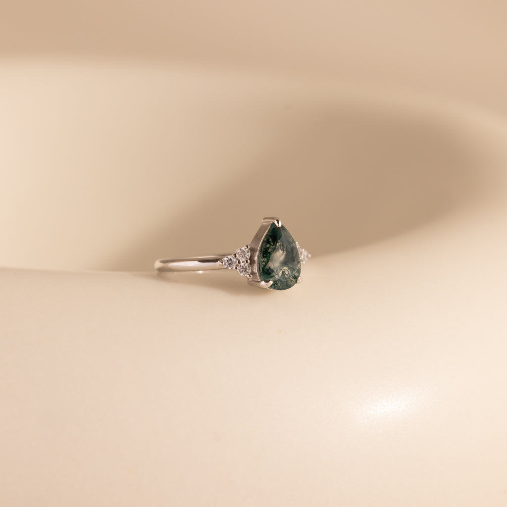 The Agate Teardrop Ring in Sterling Silver is displayed elegantly on a white surface.