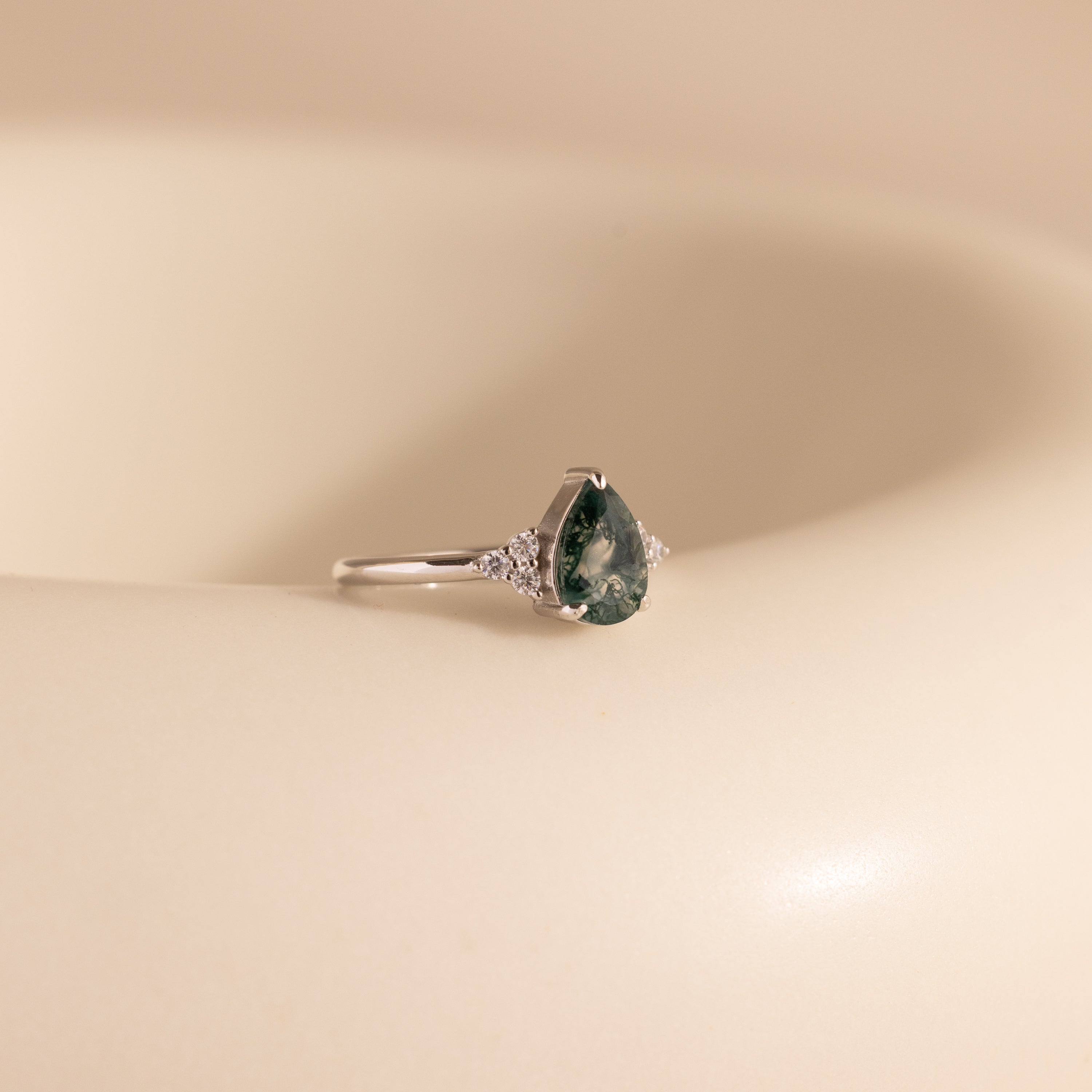 The Agate Teardrop Ring in Sterling Silver is displayed elegantly on a white surface.