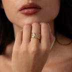 A woman’s hand with the Mosaic Diamond Baguette Ring, its bold pattern gleaming, rests near her lips.