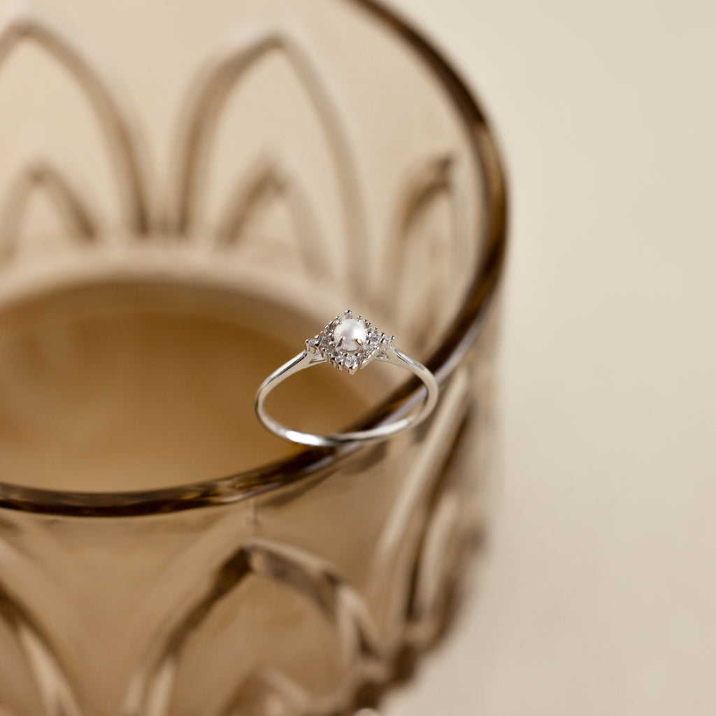 The Vintage Pave Pearl Ring in Sterling Silver showcases a central pearl with pavé diamonds in a square setting on a reflective gold band—an elegant and exquisite Christmas gift choice.