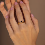 A hand with light pink nails wears three stacked silver rings, featuring black and white accents, showcasing the chic Black Abyss Ring Set in Silver on the middle finger.