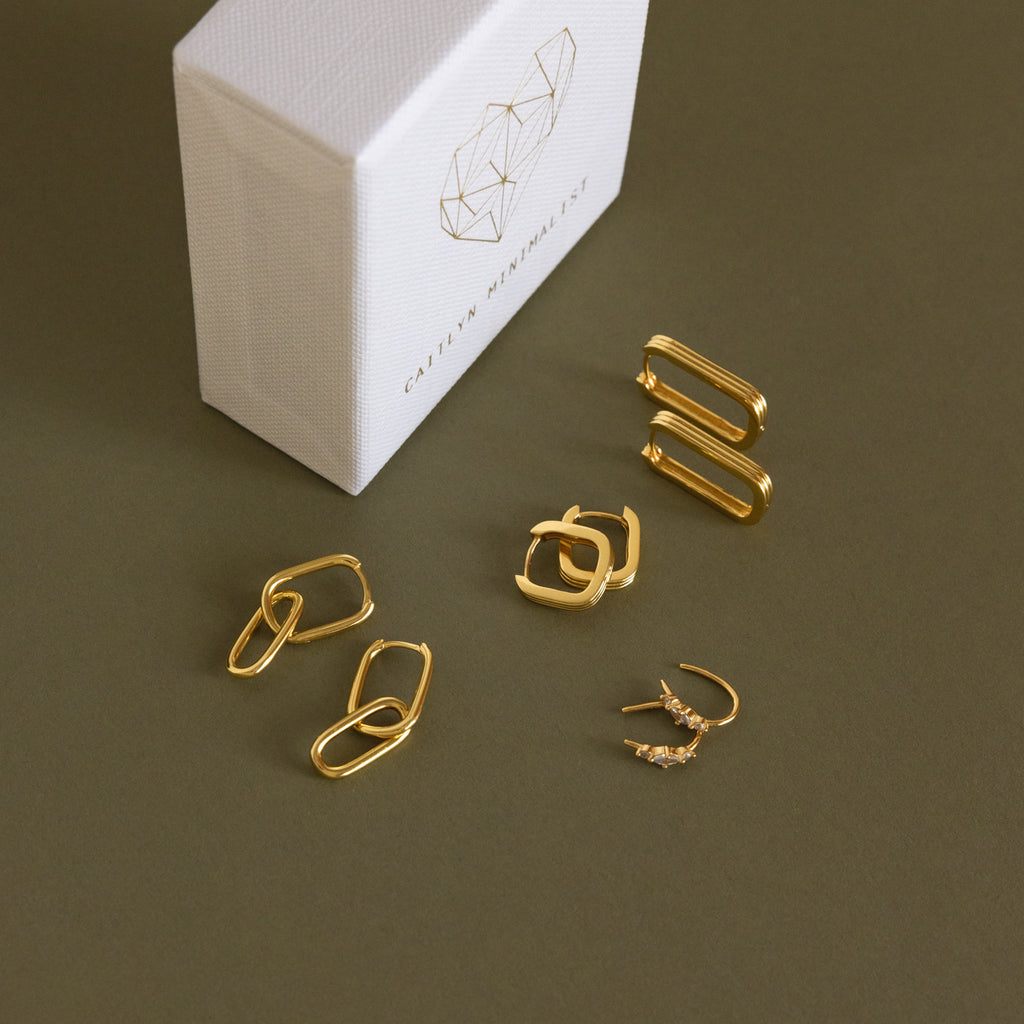 A Monthly Earrings Subscription Box with new 18K gold earrings and paperclips.