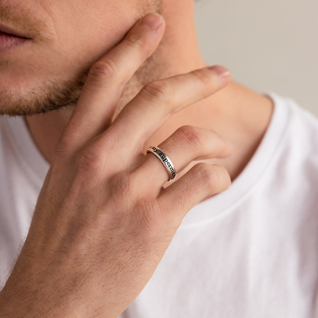 A man in a white shirt touches his face, wearing the stylish Half Round Fingerprint Ring on his finger.