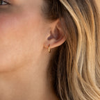 Close-up of a woman's ear adorned with Small Bold Hoops—minimalist earrings that look chic with her blonde hair, ideal for daily wear.