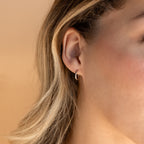 Close-up of a woman's ear wearing the Small Bold Hoops in Sterling Silver—minimalist hoops perfect for everyday wear, with blonde hair partially visible.