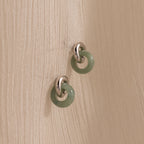 Jade Halo Drop Studs: Smooth green jade rings linked to silver studs, minimalist design.
