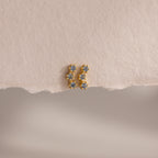 Aquamarine Cluster Flatback Studs: small gold earrings with blue gemstones, shown on a textured light beige surface. Elegant birthstone studs, perfect for any occasion.
