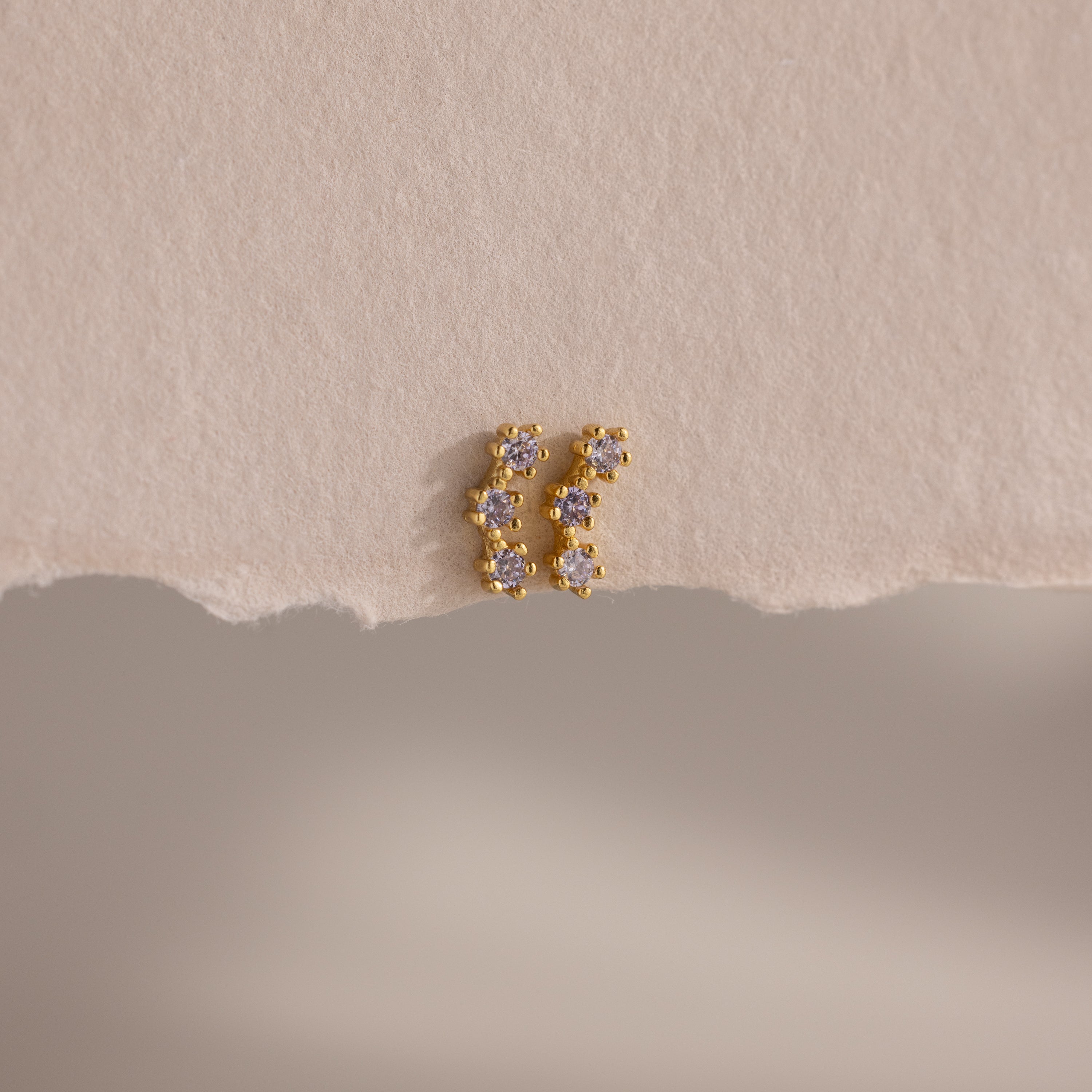 Alexandrite Cluster Flatback Studs featuring small, sparkling stones, displayed on a textured, off-white paper background.