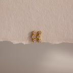 Pink Tourmaline Cluster Flatback Studs featuring small, pink stones are showcased on a textured, torn beige paper background.