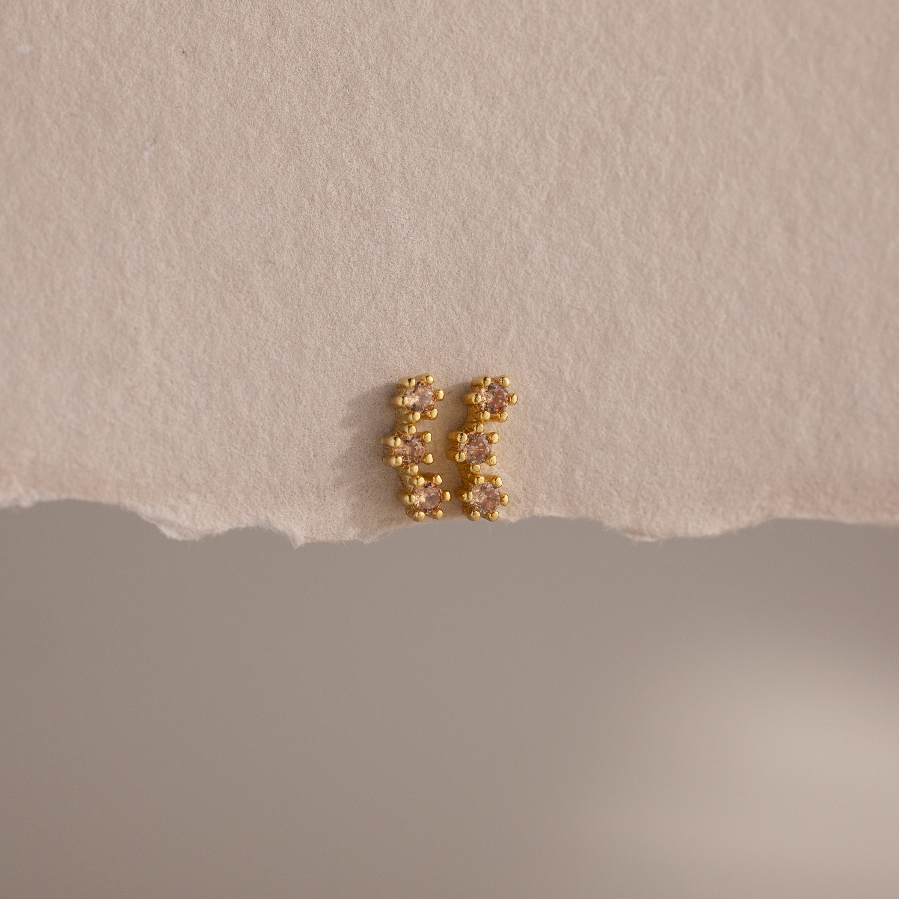 Topaz Cluster Flatback Studs are displayed on torn beige paper against a neutral background.
