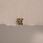 Sapphire Cluster Flatback Studs with small blue stones, photographed on textured beige paper with a torn edge—perfect for adding sparkle to your earring stack.