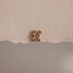 Amethyst Cluster Flatback Studs featuring small purple gemstones are displayed on a textured beige surface.