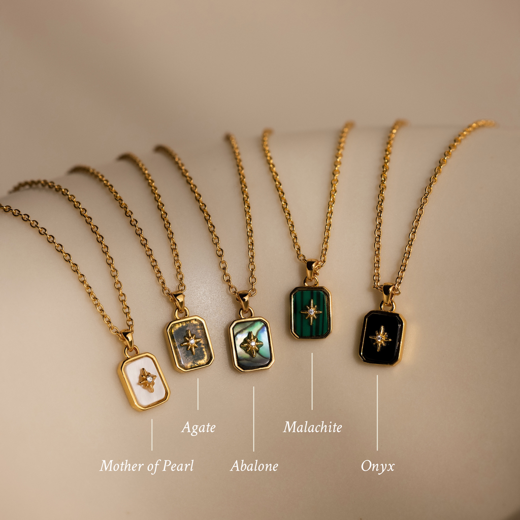 A row of necklaces featuring various designs, including a crystal pendant and the North Star Gemstone Necklace in 18K Gold.