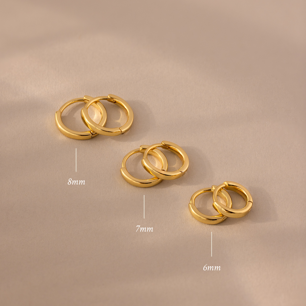 The Dainty Huggies Set features three pairs of gold hoop earrings in 8mm, 7mm, and 6mm sizes—ideal minimalist earrings for your collection.