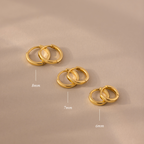 The Dainty Huggies Set features three pairs of gold hoop earrings in 8mm, 7mm, and 6mm sizes—ideal minimalist earrings for your collection.