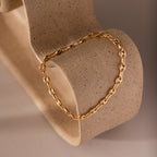 Mini Mariner Chain Bracelet displayed on a sculptural stone form, showcasing its delicate gold links and polished finish.