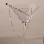 Silver mariner chain necklace with polished oval links, elegantly draped over the rim of a clear martini glass with a silver stir stick.