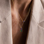 Close-up of a person wearing the Duo Birthstone Name Necklace with vibrant rectangular pendants over a beige blazer—a personalized keepsake featuring custom name engraving.