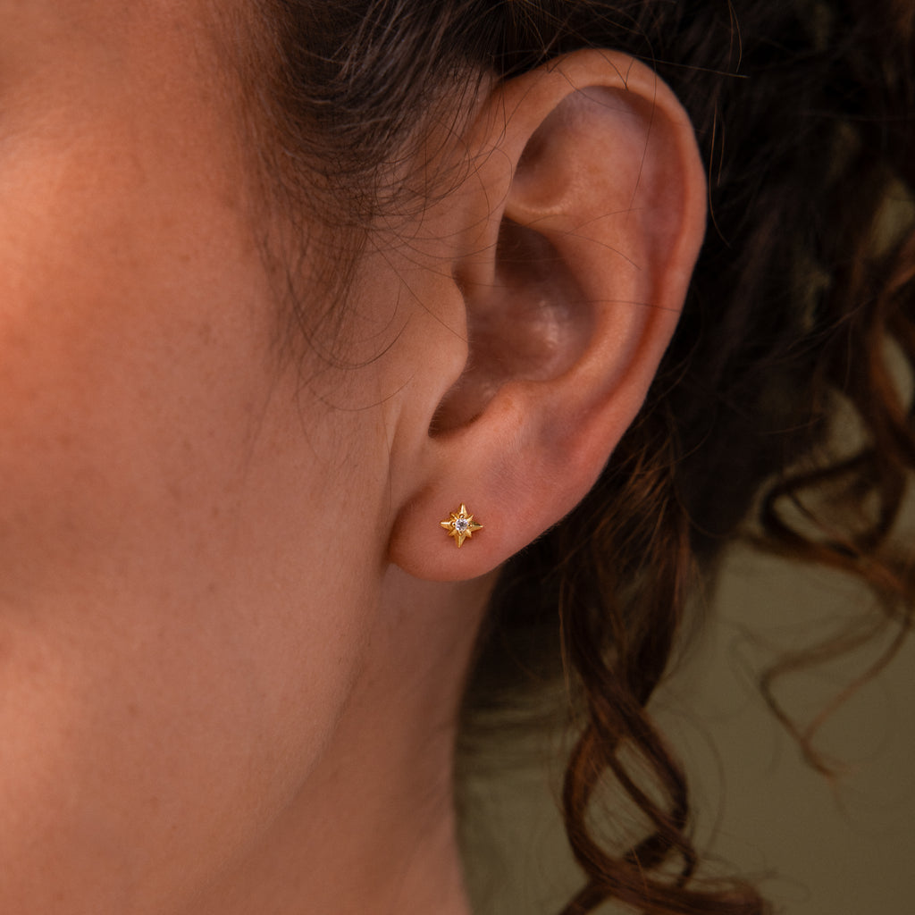 Close-up of a model wearing our Starlight Flatback studs in Gold