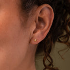 Close-up of a model wearing our Starlight Flatback studs in Gold