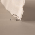 A Flatback Applicator Tool is placed on a beige surface next to torn paper.
