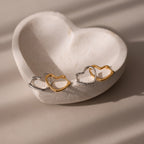 Heart-shaped earrings in gold and silver on a heart-shaped stone