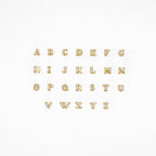 Pave Initial Studs: Gold alphabet letters with rhinestones, arranged in three rows on a white background—ideal as custom initial stud earrings or a unique personalized gift.