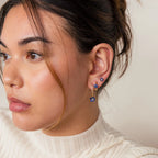 A woman wearing the Sapphire Flower Earrings Set and a white sweater.