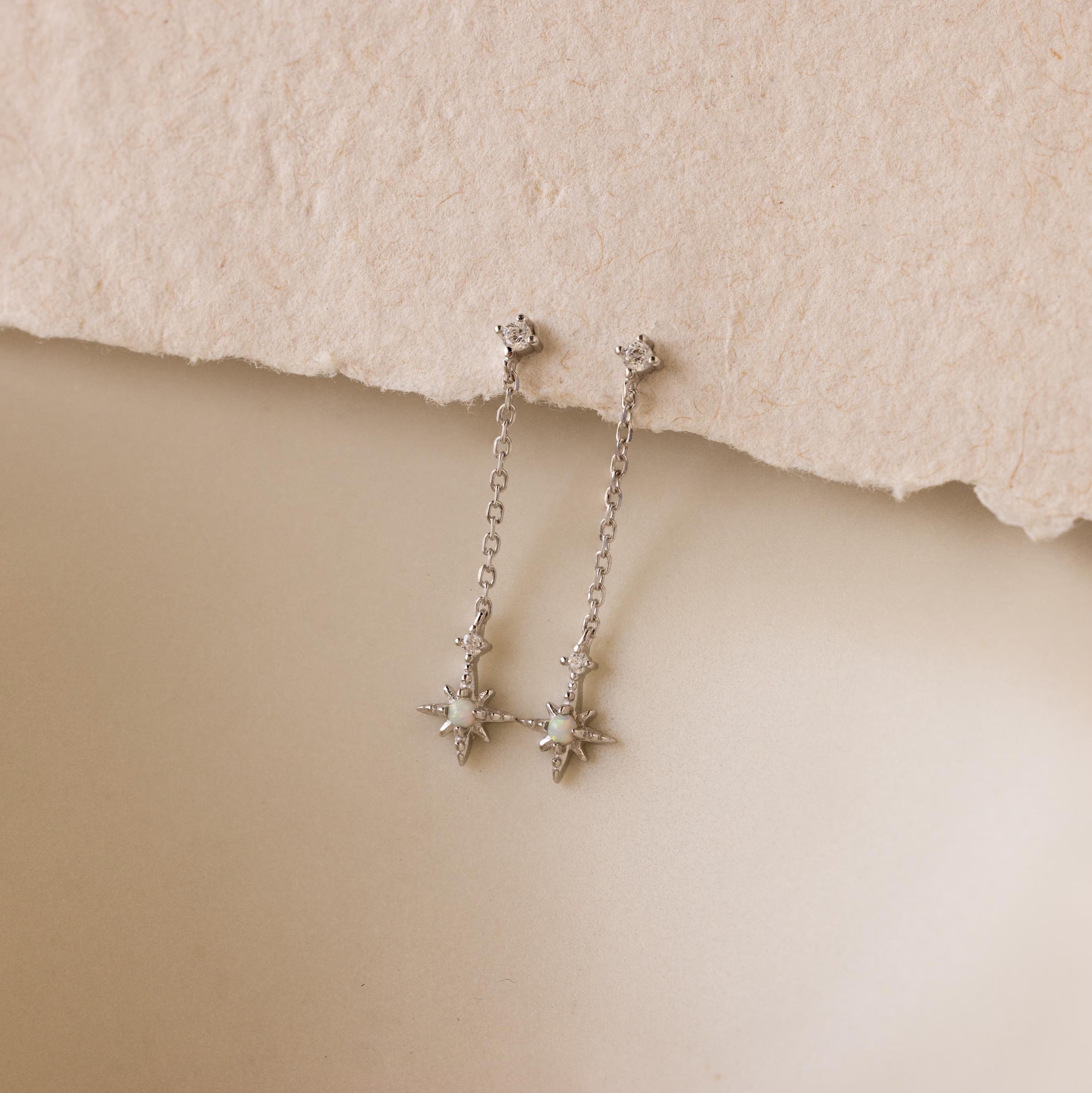 Close up of silver Starburst Chain Stud Earrings