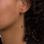 Close-up of Agate Threader Earrings in gold, highlighted by a green gemstone and worn with curly hair—a chic, contemporary accessory for effortless daily elegance.