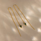 Agate Threader Earrings featuring delicate chains and green moss agate gemstone pendants are displayed on a beige surface for a modern, elegant look.
