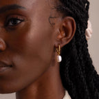 Woman wearing a Twisted Pearl Hoop Earring in gold; side view highlighting the earring’s fit and drop on the earlobe.