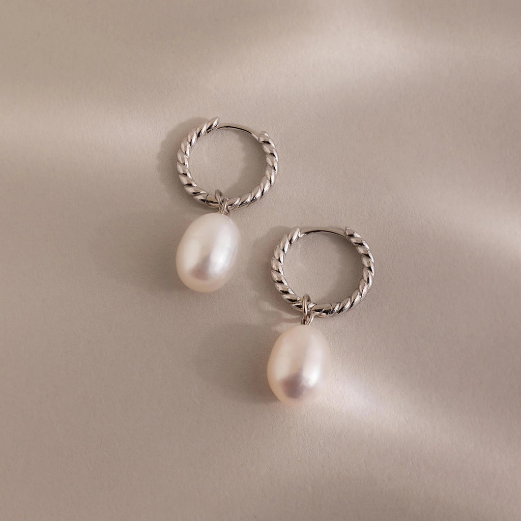 Pair of silver twisted hoop earrings with white freshwater pearls.