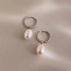 Pair of silver twisted hoop earrings with white freshwater pearls.
