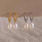 Side-by-side comparison of the gold and silver versions of the Twisted Pearl Hoop Earrings, all four displayed hanging from a neutral paper edge.