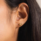 Side profile of a woman wearing one Twisted Snake Earring in gold on her earlobe