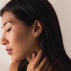 Side profile of a woman wearing the silver version of the Twisted Snake Earrings.
