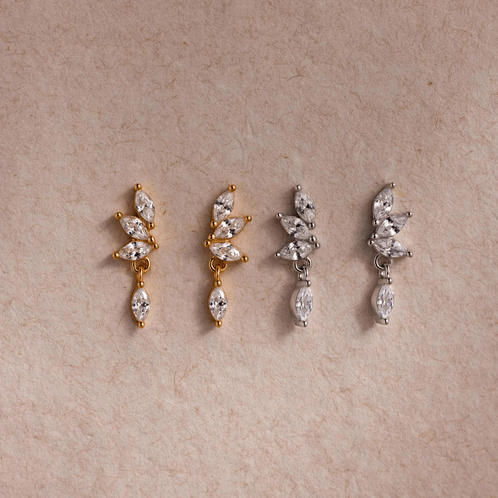 Two pairs of CZ diamond drop earrings in gold and silver, each with four marquise-cut stones.