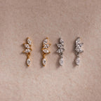 Two pairs of CZ diamond drop earrings in gold and silver, each with four marquise-cut stones.