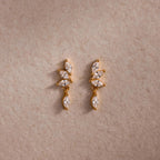 Gold CZ diamond drop earrings with four marquise-cut stones.