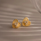 Close-up of a pair of gold Ribbed Heart Initial Stud Earrings with the letter A in pave detailing.