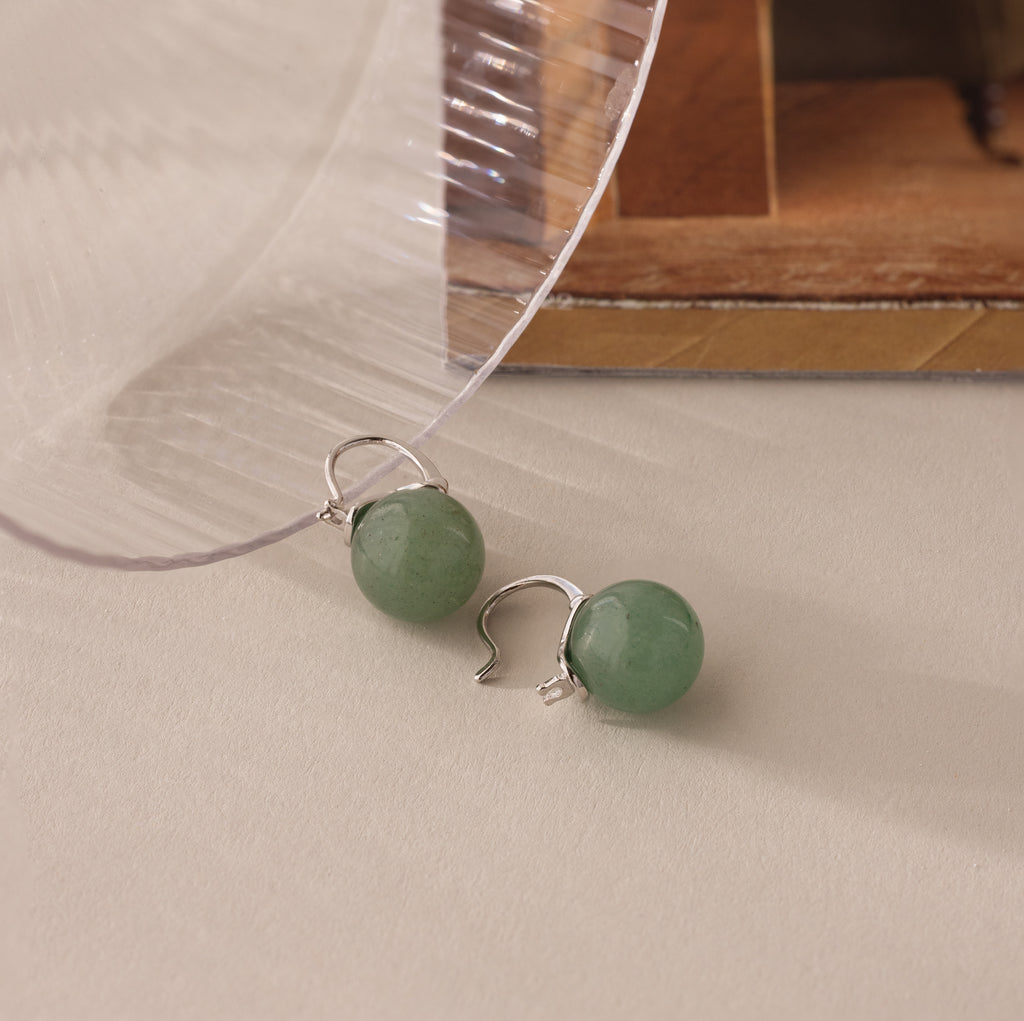 Close-up of silver Jade Dome Drop Earrings featuring rounded green gemstones on dainty hoops.