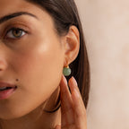 Model wearing Jade Dome Drop Earrings featuring rounded green gemstones on dainty gold hoops.