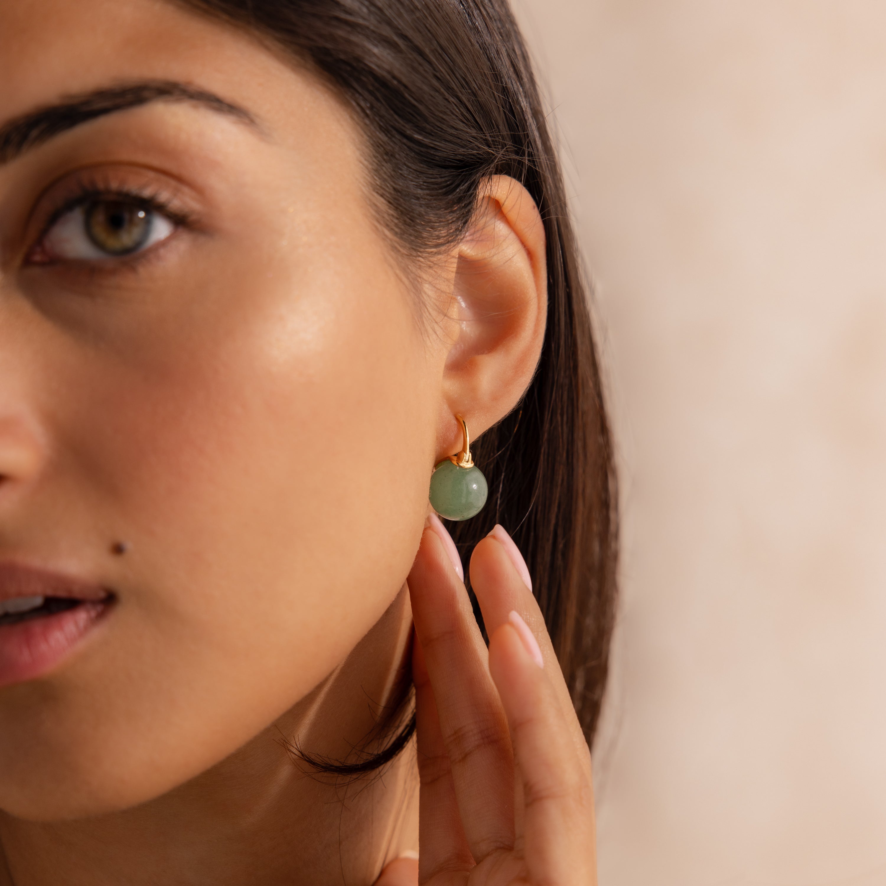 Model wearing Jade Dome Drop Earrings featuring rounded green gemstones on dainty gold hoops.